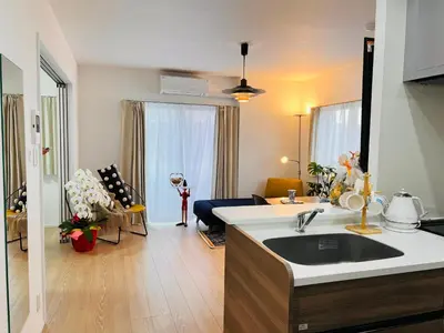 a kitchen with a sink and a living room at Tsubasa Home in Tokyo