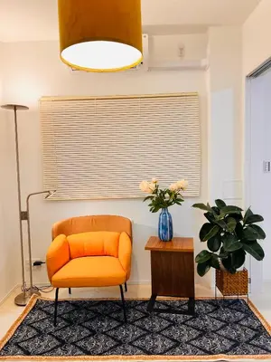 an orange chair in a living room with a table at Tsubasa Home in Tokyo