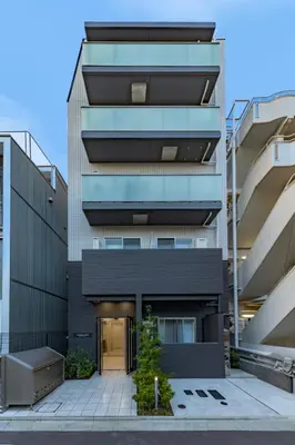 an apartment building with a black facade at Tsubasa Home in Tokyo