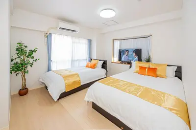 a bedroom with two beds and a window at KYARA Hotel\u30df\u30b9\u30df302 in Tokyo