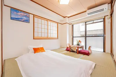 a bedroom with a bed and a table with chairs at KYARA Hotel\u30df\u30b9\u30df302 in Tokyo