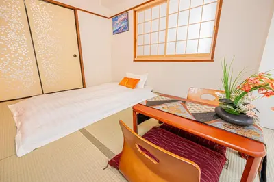 a room with a desk and a table with a bed at KYARA Hotel\u30df\u30b9\u30df302 in Tokyo