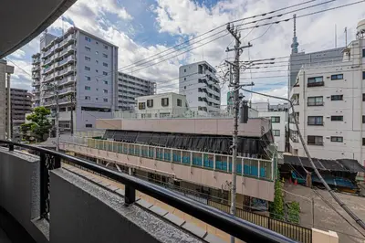a train on tracks in a city with buildings at KYARA Hotel\u30df\u30b9\u30df302 in Tokyo