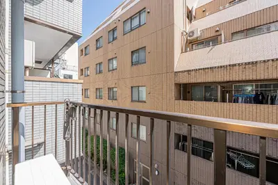 a balcony of a brick building with a bench at KYARA Hotel\u30df\u30b9\u30df302 in Tokyo