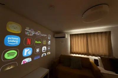 a room with a couch and a bunch of apps on the wall at HOTEL Grand Star Tokyo in Tokyo