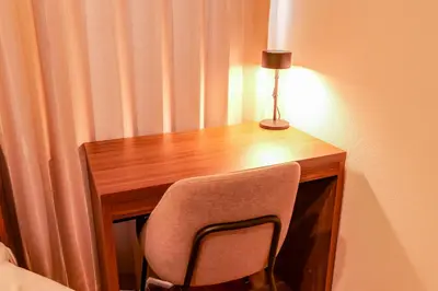 a wooden desk with a chair and a lamp on it at HOTEL Grand Star Tokyo in Tokyo