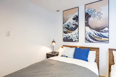 a bedroom with a bed with three pictures on the wall at Modern Japan \u6771\u4eac\u6d45\u8349 east in Tokyo