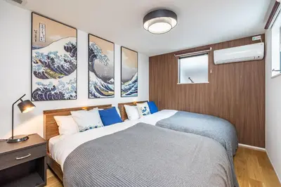 a bedroom with a large bed with paintings on the wall at Modern Japan \u6771\u4eac\u6d45\u8349 east in Tokyo