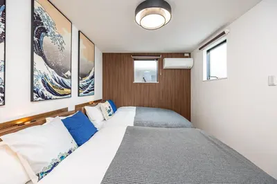 a bedroom with a bed with blue and white pillows at Modern Japan \u6771\u4eac\u6d45\u8349 east in Tokyo