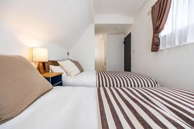 two beds in a small room with two beds at Modern Japan \u6771\u4eac\u6d45\u8349 east in Tokyo