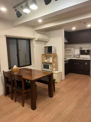a kitchen and dining room with a wooden table and chairs at Miaoyi Asakusa in Tokyo