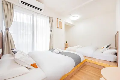 a bedroom with three beds and a window at New Cozy APT Located on the Japanese Local shopping street in Tokyo