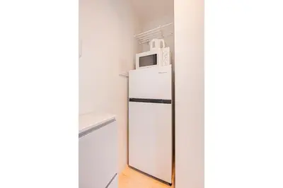 a white refrigerator with a microwave on top of it at New Cozy APT Located on the Japanese Local shopping street in Tokyo
