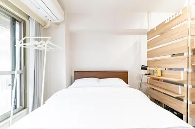 a bedroom with two beds and a window at Shinjuku myroom in Tokyo