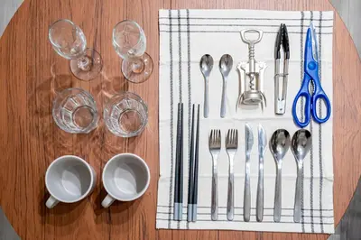 a wooden table with silverware and wine glasses on it at Shinjuku myroom in Tokyo