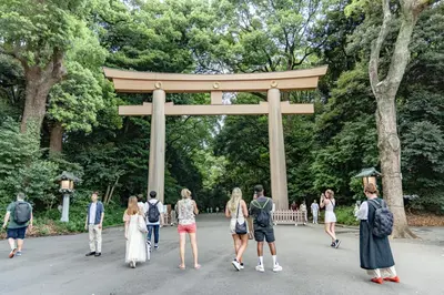 a group of people walking in front of a torii gate at HOTEL Shibuya Tomigaya in Tokyo