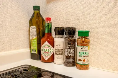 a shelf with bottles of sauce and condiments on it at HOTEL Shibuya Tomigaya in Tokyo