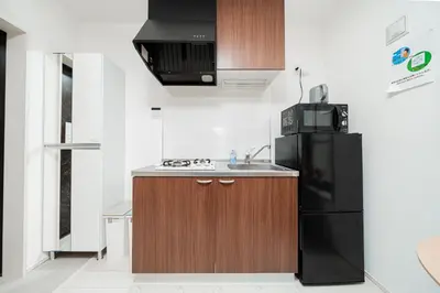 a kitchen with a black refrigerator and a sink at Momo-stay Ikebukuro in Tokyo