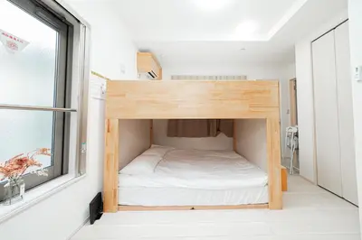 a small bed in a small room with a window at Momo-stay Ikebukuro in Tokyo