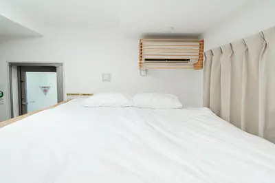 a white bed in a bedroom with a window at Momo-stay Ikebukuro in Tokyo
