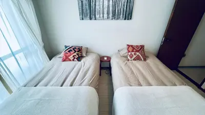 a room with two beds and a window at Shinjuku spacious apartment for max 8ppl in Tokyo