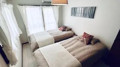 a small room with two beds and a window at Shinjuku spacious apartment for max 8ppl in Tokyo