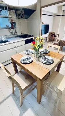 a wooden table with plates and flowers on it in a kitchen at Shinjuku spacious apartment for max 8ppl in Tokyo