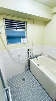 a bathroom with a bath tub and a window at Shinjuku spacious apartment for max 8ppl in Tokyo