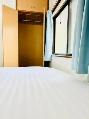 a white bed in a room with a window at Holiday Akabane House - A Traditional Japanese House in Tokyo, with Direct Access to Shinjuku & Shibuya in Tokyo