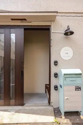 an entrance to a building with a door and a mailbox at \u6771\u6d45\u83492\u4e01\u76eeb101 in Tokyo