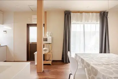 a room with a bed and a kitchen with a window at \u6771\u6d45\u83492\u4e01\u76eeb101 in Tokyo
