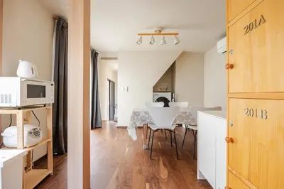 a kitchen and a living room with a table and chairs at \u6771\u6d45\u83492\u4e01\u76eeb101 in Tokyo