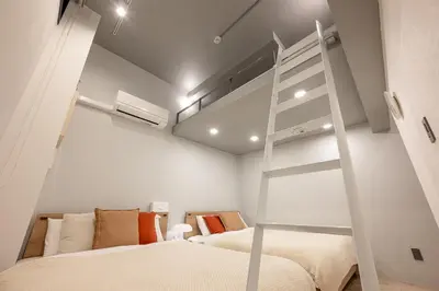 a bedroom with two beds and a ladder in it at 24\u5e749\u6708\u30aa\u30fc\u30d7\u30f3 \u767d\u5c71\u99c55\u5206 \u53ce\u5bb912\u4eba \u4e38\u8cb8\u3057\u5207\u308a 101\u5ba4 in Tokyo