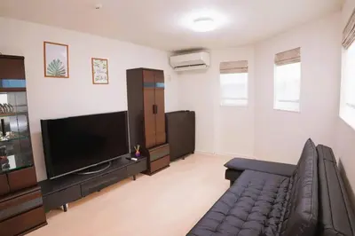 a living room with a couch and a flat screen tv at \u5168\u65b0\u8bbe\u5907\u8bbe\u65bd 3\u5c42102\u5e73\u65b9\u72ec\u680b\u6d0b\u623f4\u5ba41\u53852\u536b2\u4e2a\u6d17\u6fa1\u95f4 \u53a8\u623f\u5b8c\u5907 \u4ea4\u901a\u4fbf\u5229 in Tokyo