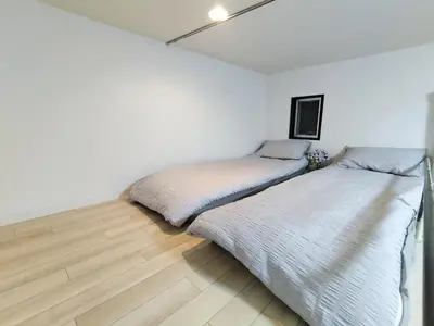 two beds in a white room with wood floors at D12\u65b0\u5bbf\u6700\u4e2d\u5fc3 \u4e24\u5ba4 \u65b0\u5927\u4e45\u4fdd\u7ad95\u5206-2 rooms Shinjuku center 5 mins to ST Max 4P \u65b0\u5bbf \u6d89\u8c37 \u8868\u53c2\u9053 \u6c60\u888b \u4e0a\u91ce \u4ee3\u4ee3\u6728 \u94f6\u5ea7 \u539f\u5bbf in Tokyo