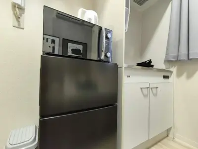 a black refrigerator with a microwave on top of it at D12\u65b0\u5bbf\u6700\u4e2d\u5fc3 \u4e24\u5ba4 \u65b0\u5927\u4e45\u4fdd\u7ad95\u5206-2 rooms Shinjuku center 5 mins to ST Max 4P \u65b0\u5bbf \u6d89\u8c37 \u8868\u53c2\u9053 \u6c60\u888b \u4e0a\u91ce \u4ee3\u4ee3\u6728 \u94f6\u5ea7 \u539f\u5bbf in Tokyo