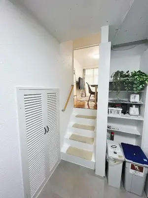 a stairway leading to a room with a white door at Ikebukuro NO'3 in Tokyo