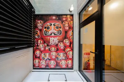 a wall with a painting of a mask on it at E JOY INN-Higashi Nipoori in Tokyo