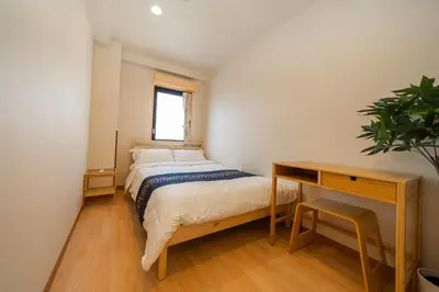 a small bedroom with a bed and a desk at E JOY INN-Higashi Nipoori in Tokyo
