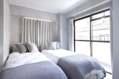 two beds in a room with a window at 1 line to Asakusa! Projector, 5 mins walk from Togoshi-ginza Sta in Tokyo
