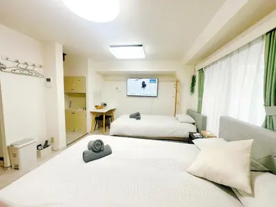 a hotel room with two beds and a tv at \u65b0\u5bbf\u5e02\u4e2d\u5fc3\u6b4c\u821e\u4f0e\u753a\u6771\u65b0\u5bbf\u99c5\u5f92\u6b653\u5206\u9418\u514d\u8cbbWi-Fi in Tokyo