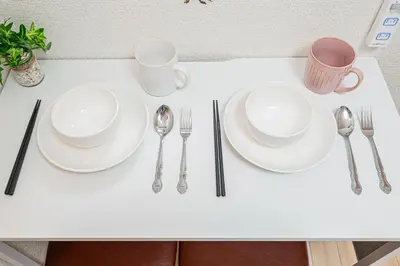 a table with white plates and silverware on it at \u65b0\u5bbf\u5e02\u4e2d\u5fc3\u6b4c\u821e\u4f0e\u753a\u6771\u65b0\u5bbf\u99c5\u5f92\u6b653\u5206\u9418\u514d\u8cbbWi-Fi in Tokyo