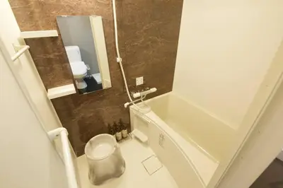 a small bathroom with a tub and a toilet at The Geminis Ikebukuro301 in Tokyo