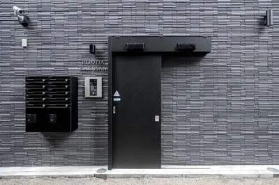 a black door on a brick building at 24\u5e749\u6708\u30aa\u30fc\u30d7\u30f3 \u767d\u5c71\u99c55\u5206 \u53ce\u5bb95\u4eba \u4e38\u8cb8\u3057\u5207\u308a 102\u5ba4 in Tokyo