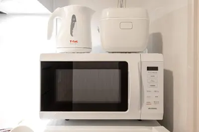 a white microwave with two appliances on top of it at 24\u5e749\u6708\u30aa\u30fc\u30d7\u30f3 \u767d\u5c71\u99c55\u5206 \u53ce\u5bb92\u4eba \u4e38\u8cb8\u3057\u5207\u308a 201\u5ba4 in Tokyo