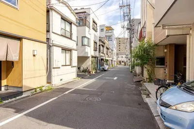 an empty street with a blue car parked on the side at \u6771\u6d45\u83492\u4e01\u76eeb201 in Tokyo