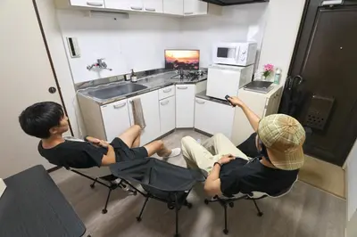 two young men sitting in chairs in a kitchen at Zen Abode404 Japanese-style and modern Western-style rooms in Tokyo