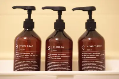 a group of four shampoo bottles sitting on a shelf at Zen Abode404 Japanese-style and modern Western-style rooms in Tokyo