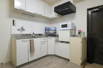 a kitchen with white cabinets and a microwave at Zen Abode404 Japanese-style and modern Western-style rooms in Tokyo