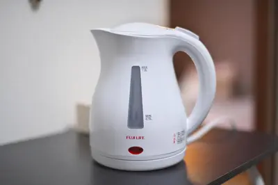 a white electric kettle sitting on a table at Zen Abode404 Japanese-style and modern Western-style rooms in Tokyo